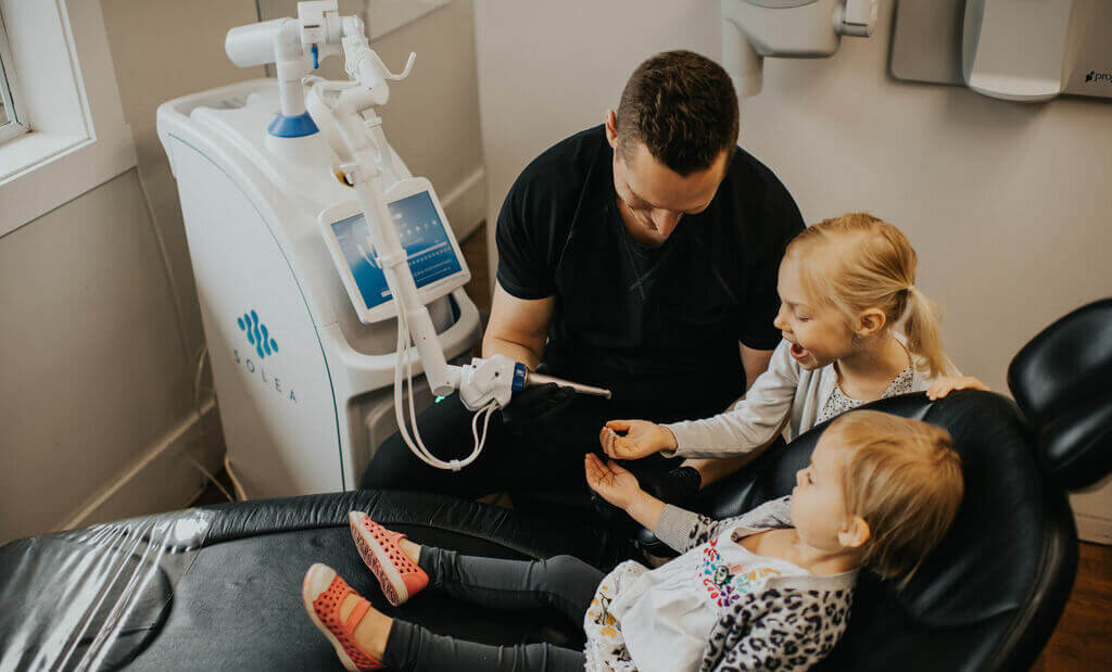 Dr. Webster showing two young girls how a tool works